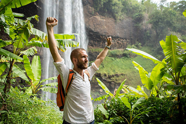 istock Explorer man in the jungle at waterfall 474505112