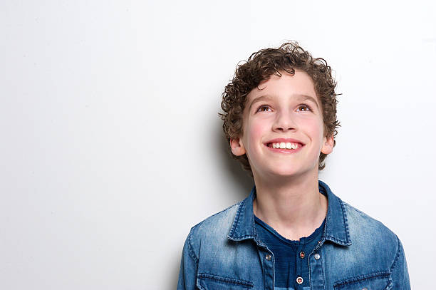 happy little boy looking up - child lifestyles isolated blue fotografías e imágenes de stock