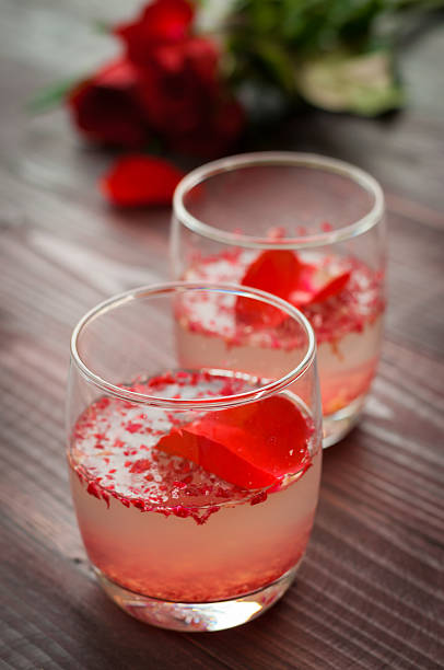 istock Pink Cocktail with fresh rose petals on wooden table 474505822