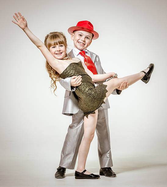 Dance Concepts. Couple of Asian Man and Caucasian Woman Performing As Ballet Dancers Over Grey in Studio As Classical Choreography and Ballet Dancing. Vertical Composition