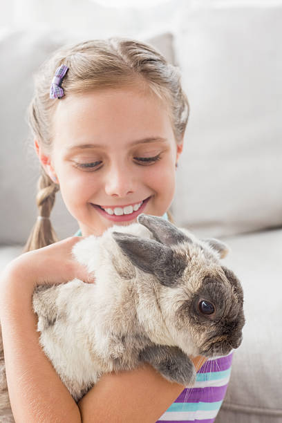 istock Girl playing with rabbit in living room 474506808