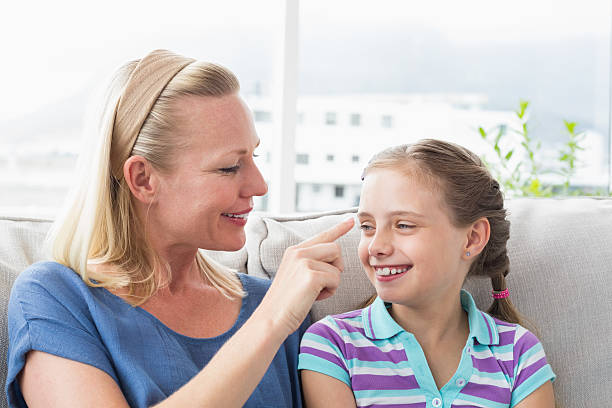 istock Mother touching daughter in living room 474509126