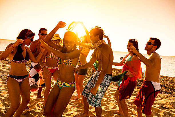 istock Spring break backlit group of young people dancing on beach 474510407