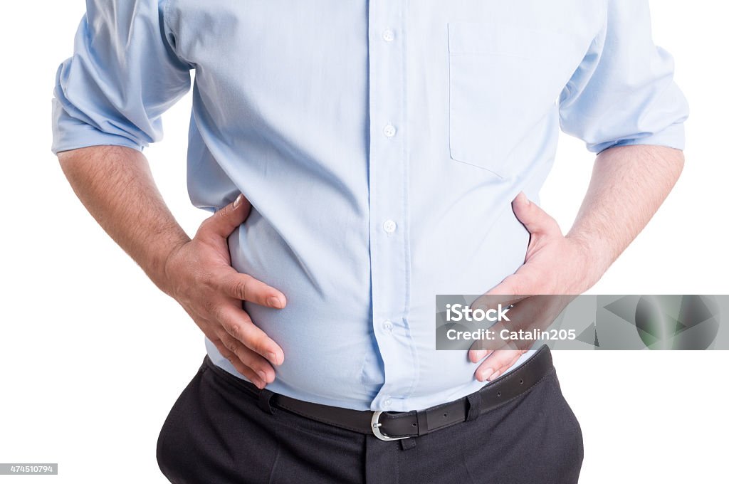 Hands grabbing bloated abdomen Hands grabbing bloated abdomen. Digestion problem or indigestion, medical concept. Abdomen Stock Photo