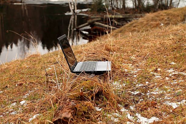 istock Laptop on the Log near Water 474512198