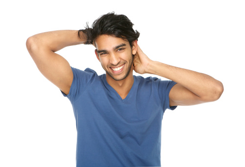 Close up horizontal portrait of a young man laughing with hand in hair