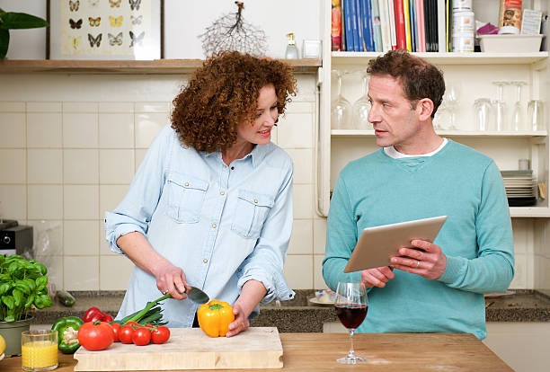 istock Husband and wife reading recipe from tablet 474516380