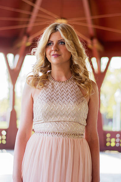 istock Blond woman in evening gown posing 474516724