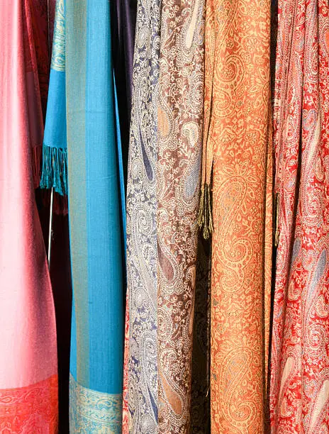 A small group of scarves for sale on an outdoor stand at the entrance to St. Mark's Square, Venice ,Italy; colors include pink, blue and orange. My wife bought one. 