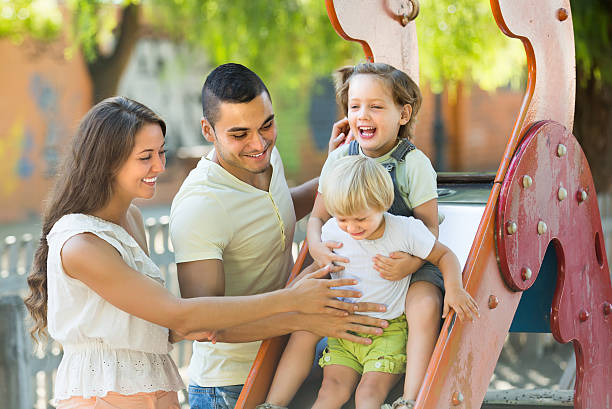 istock Family playing at children's slide 474521162