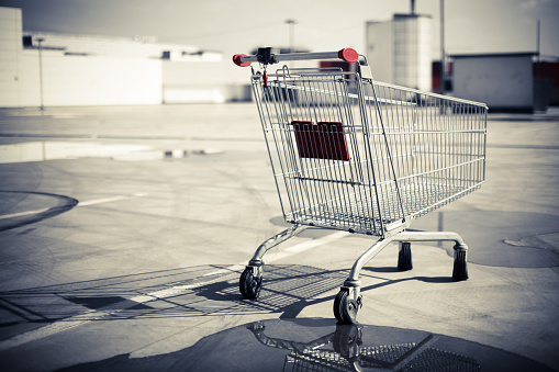 Color image of an abandoned shopping trolley in a parking lot.