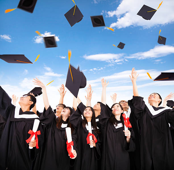 istock happy students throwing graduation caps into the Air 474523380