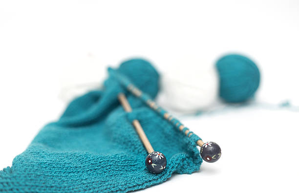 istock blue yarn knitted fabric, knitting spokes close-up 474526860