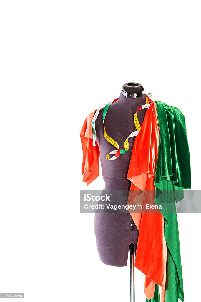 Mannequin with fabric and ribbon Mannequin with a piece of red and green fabric and measuring tape. The concept of fashion and fashion design. 2015 Stock Photo