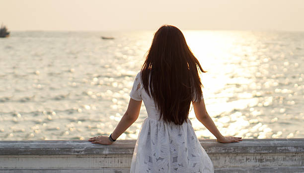 istock Girl watching sea and sunset on a balcony 474536556