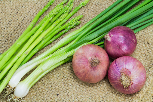 Asparagus, Onion and spring onion on sack background