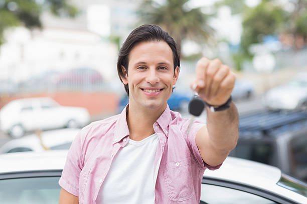 istock Young man smiling and holding key 474540236
