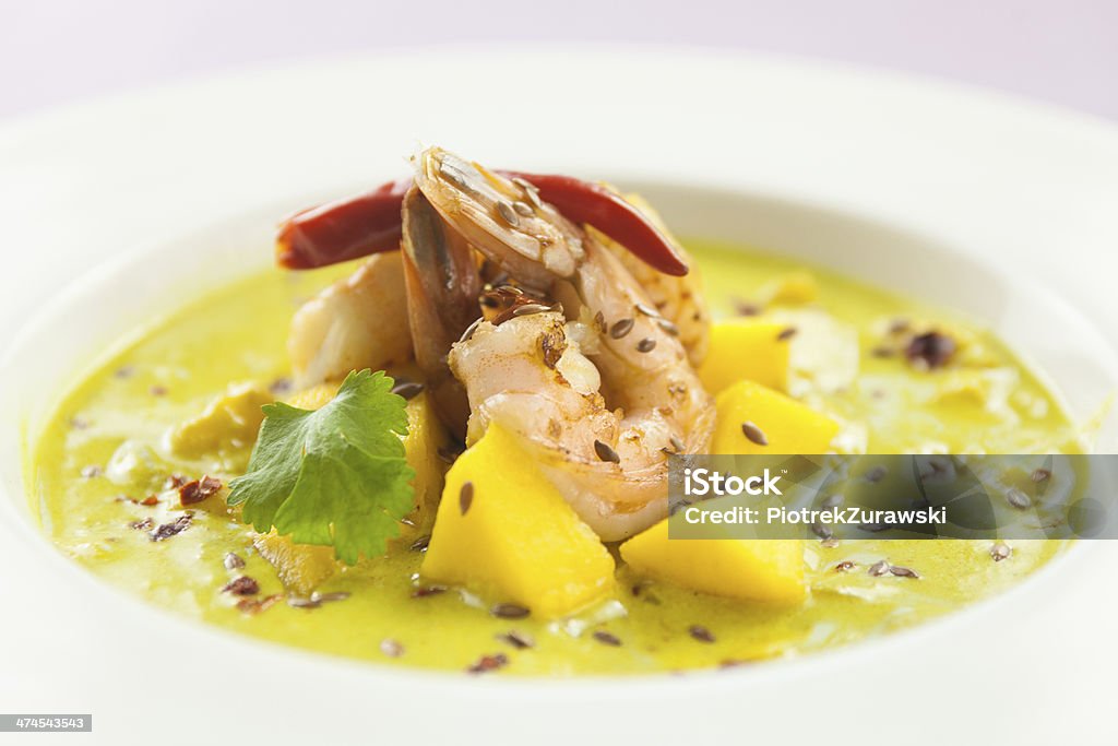 Curry soup with prawns and mango - wide Curry soup  prawns with mango, chilli, parsley and cumin Banquet Stock Photo
