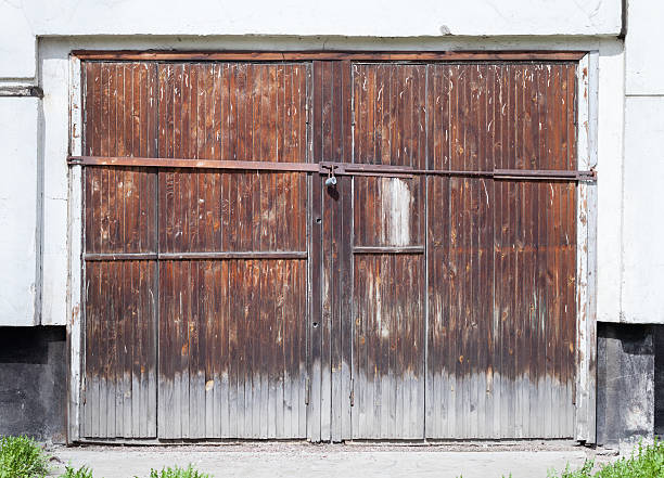 古いロック木製のゲートホワイトのコンクリートの壁 - barn red old door ストックフォトと画像