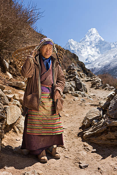 istock Old woman carrying basket in Himalayas 474551434