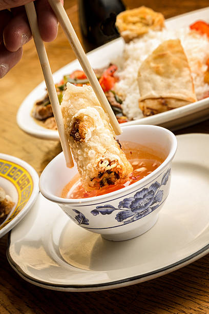 istock Fried Egg Roll being Dipped in Sweet and Sour Sauce 474553204