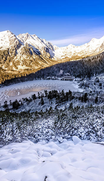istock Vertical panoramic view of winter mountains, lake and cottage, S 474557776