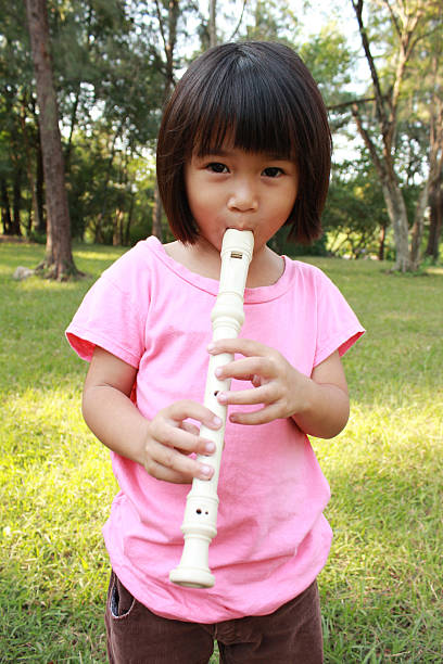 istock Young girl playing flute 474558494
