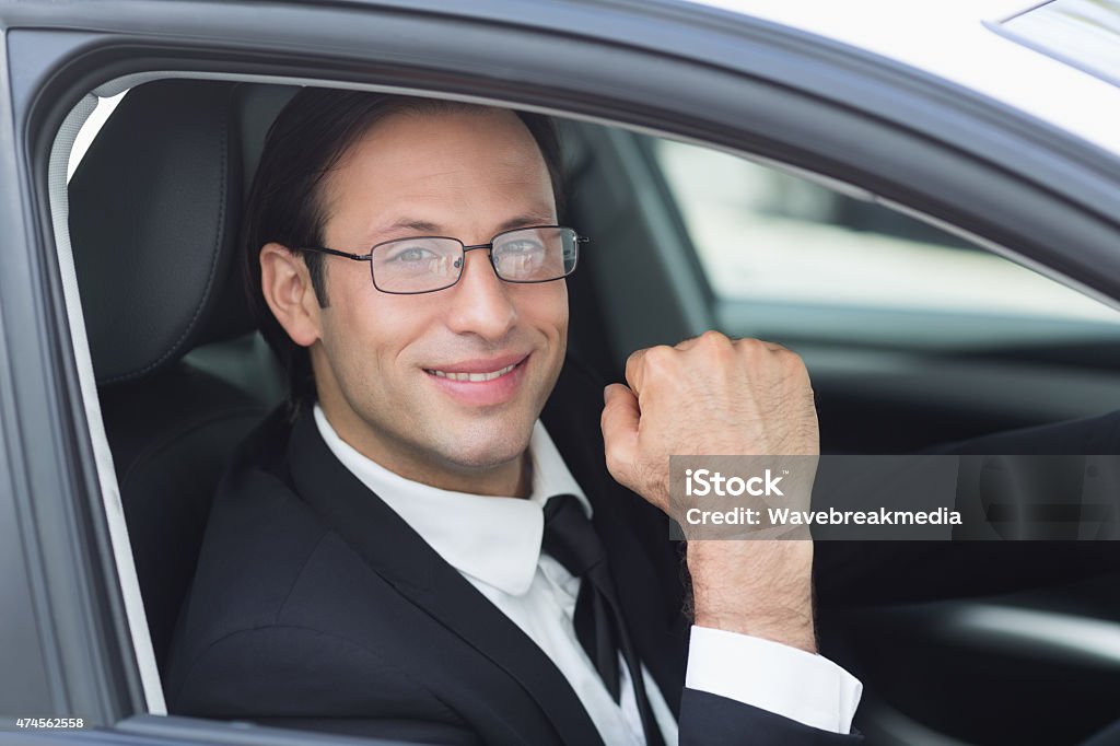 Happy businessman in the drivers seat Happy businessman in the drivers seat in his car 2015 Stock Photo