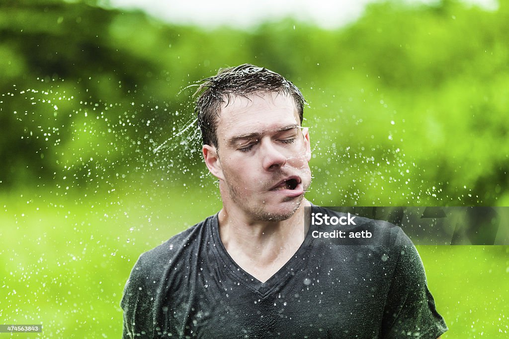 Young Adult Completely Drenched Shaking His head Young Adult Completely Drenched Shaking His head and Making a Funny Face Human Face Stock Photo