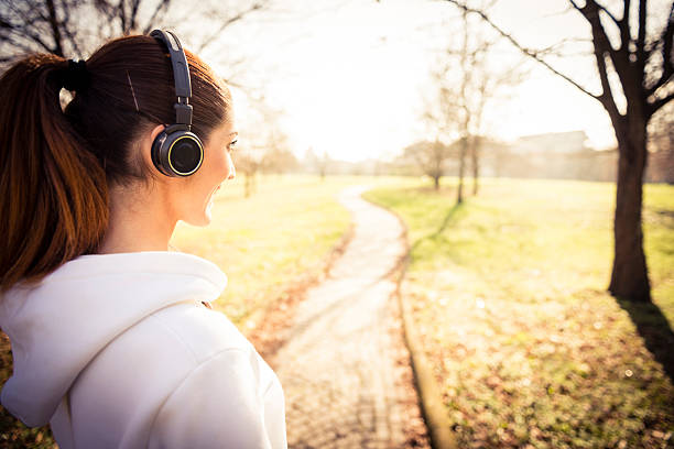 istock Young happy woman with ear phone 474563931