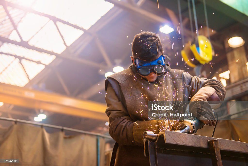 Man welding Young man with protective goggles welding in a factory Welder Stock Photo