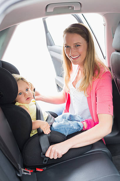 istock Mother securing her baby in the car seat 474564658