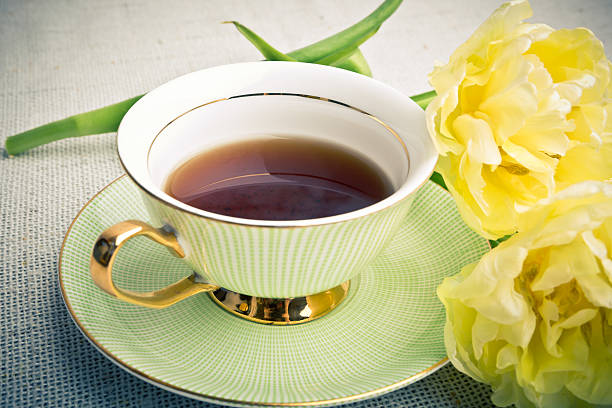 istock Cup of tea and yellow tulips 474565050