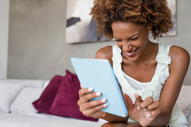 istock Young happy woman with digital tablet at home 474567357