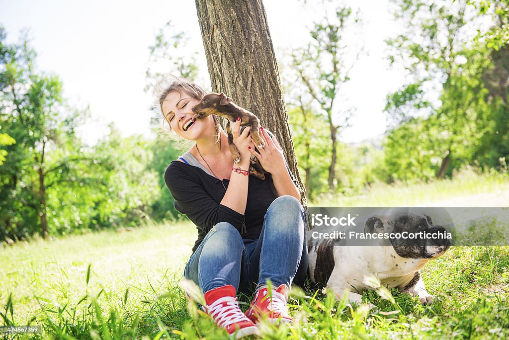 Mujer joven con dos perros - Foto de stock de Abrigo de pieles libre de derechos