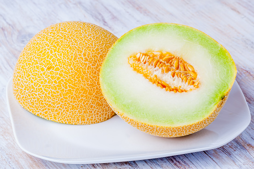 Ripe Galia melon and its slice on plate