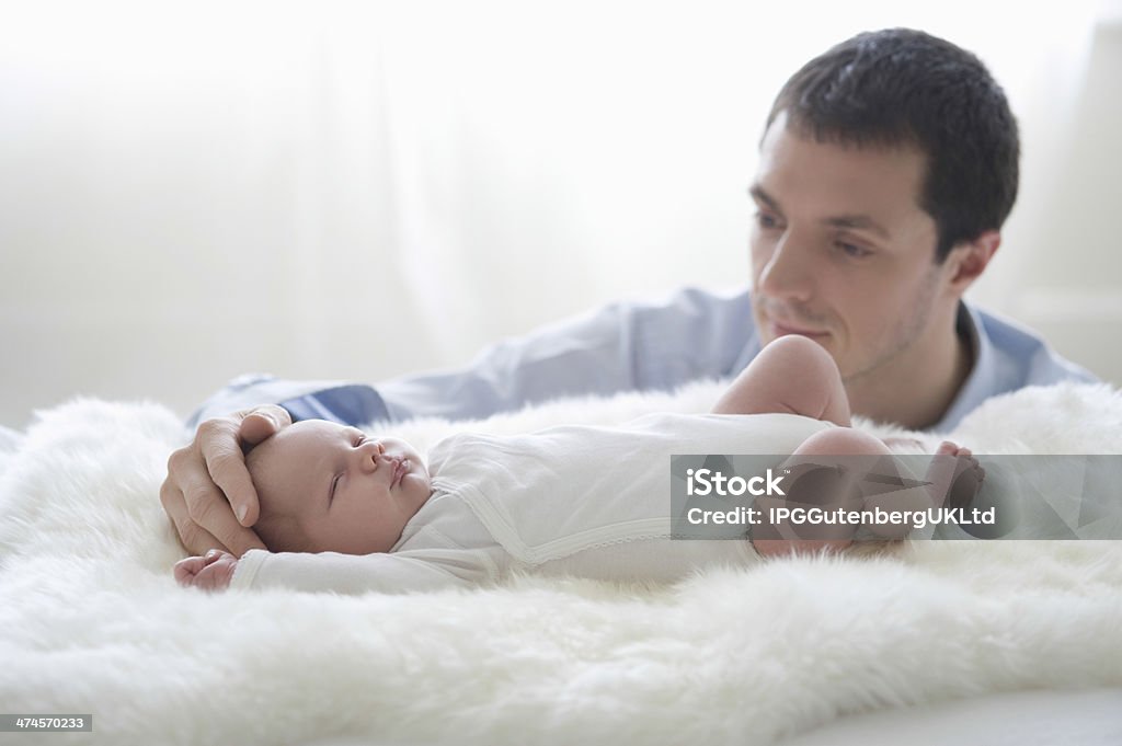 Father Caressing Newborn Baby's Head Happy father caressing newborn baby's head at home Adult Stock Photo