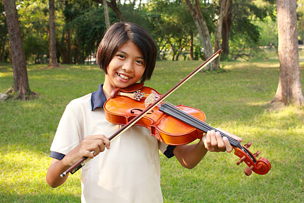 istock Happy young girl plays her violin 474574016