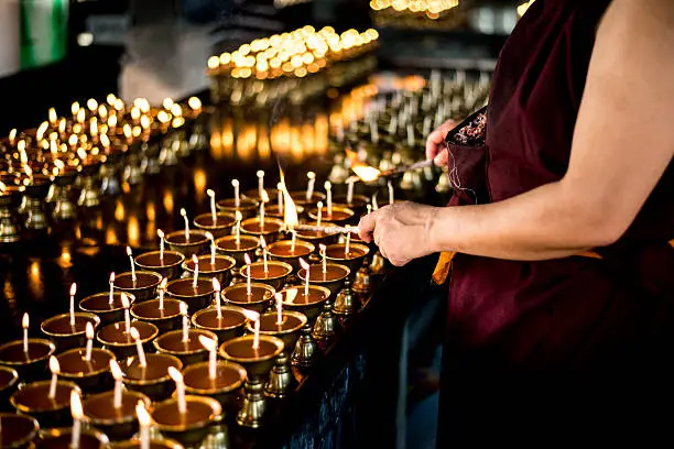 Photo of Monk Lighting Prayer lamp on Buddha Purnima