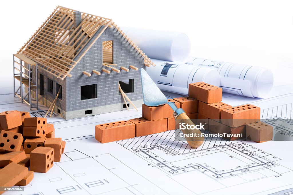 house in construction project with brick and blueprint on white House Stock Photo