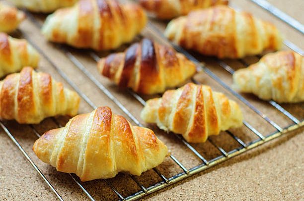 istock Fresh baked croissants on metallic rack 474608632