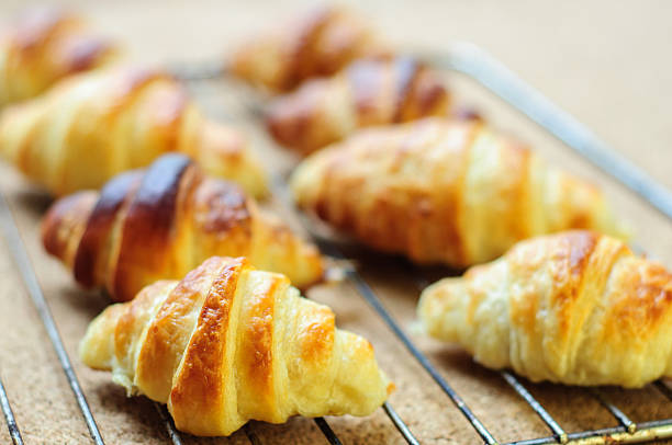 istock Fresh baked croissants on metallic rack 474608634