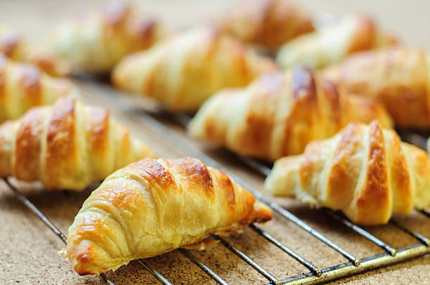 istock Fresh baked croissants on metallic rack 474608642