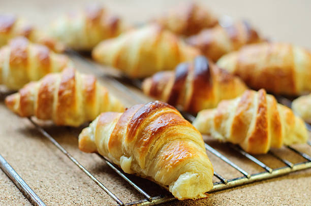 istock Fresh baked croissants on metallic rack 474608646