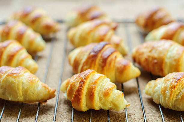 Fresh baked croissants on metallic rack