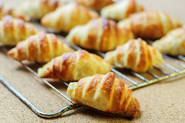 istock Fresh baked croissants on metallic rack 474608656