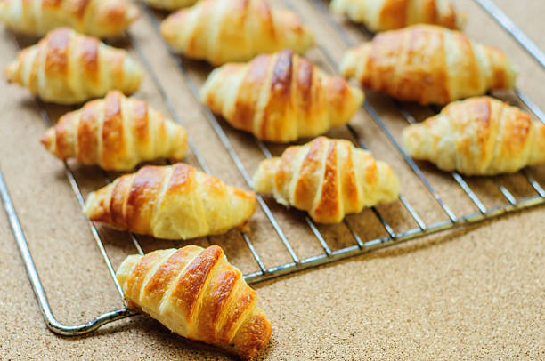 istock Fresh baked croissants on metallic rack 474608658