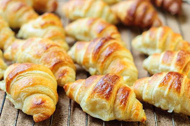 istock Fresh baked croissants on metallic rack 474608668