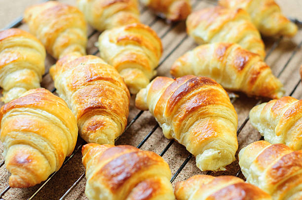 istock Fresh baked croissants on metallic rack 474608670