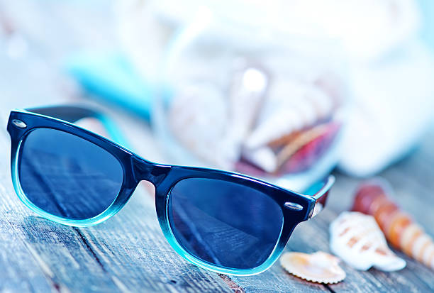 sun glasses and flip flops on wooden backgroubd